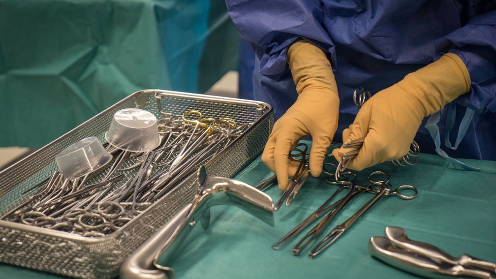 Un médico manejando instrumentos quirúrgicos