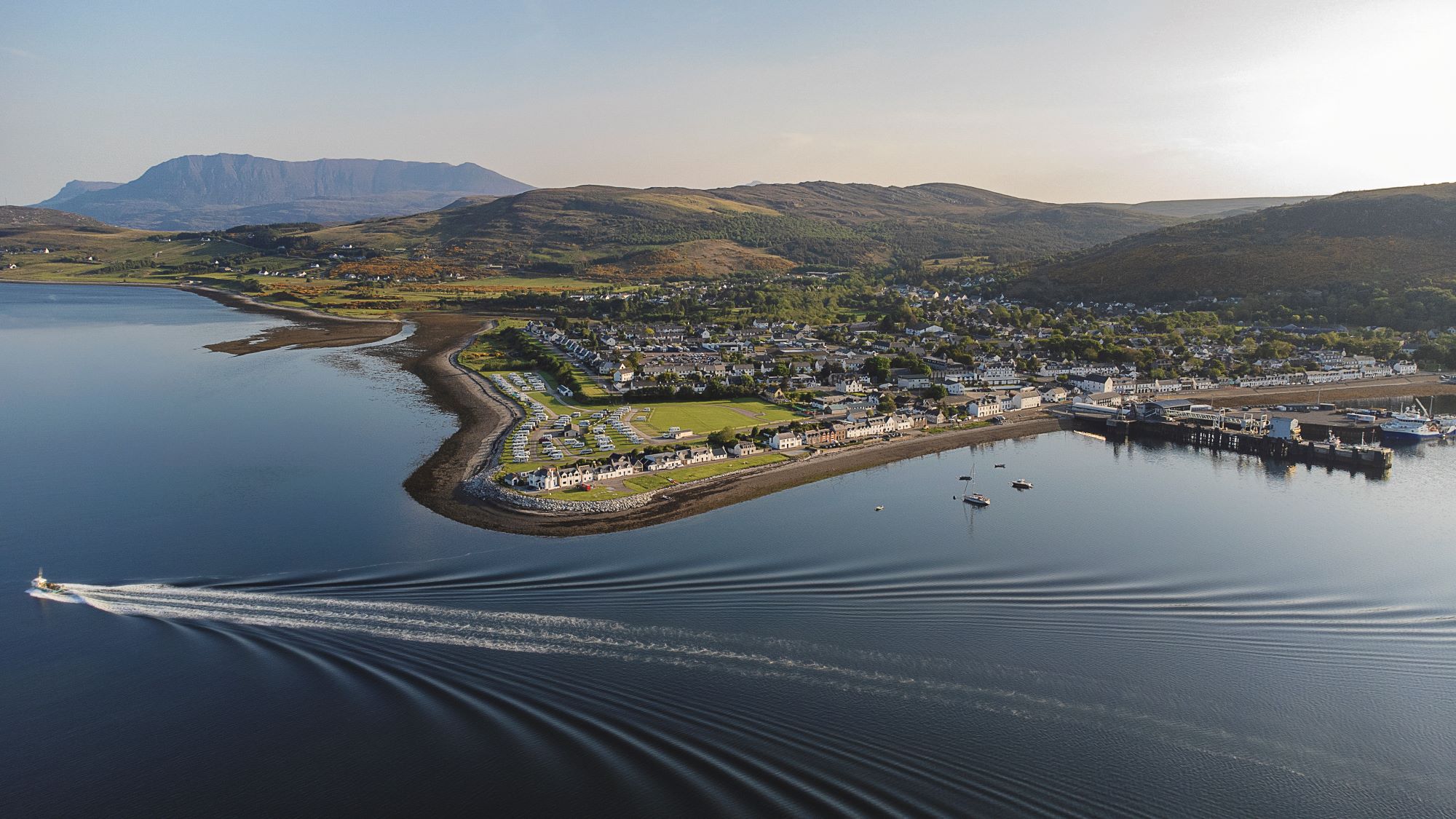 The village of Ullapool and a boat's wake on Loch Broom.