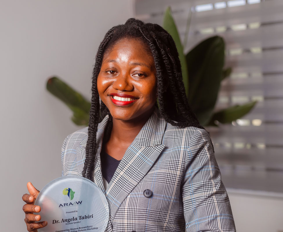 Dr Angela Tabiri smiling as she holds an award