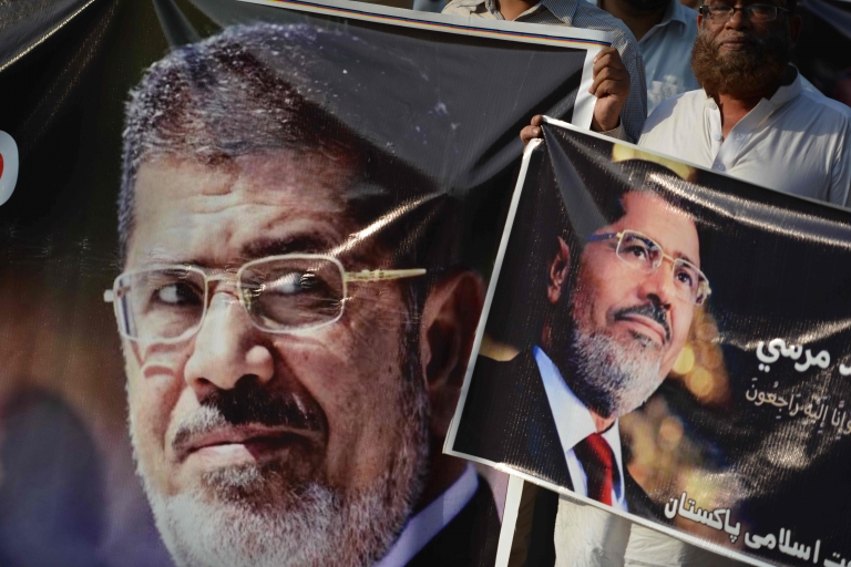 Activists of Jamaat-e-Islami hold pictures of former Egyptian President Mohamed Morsi during a symbolic funeral ceremony in Islamabad on 18 June 2019