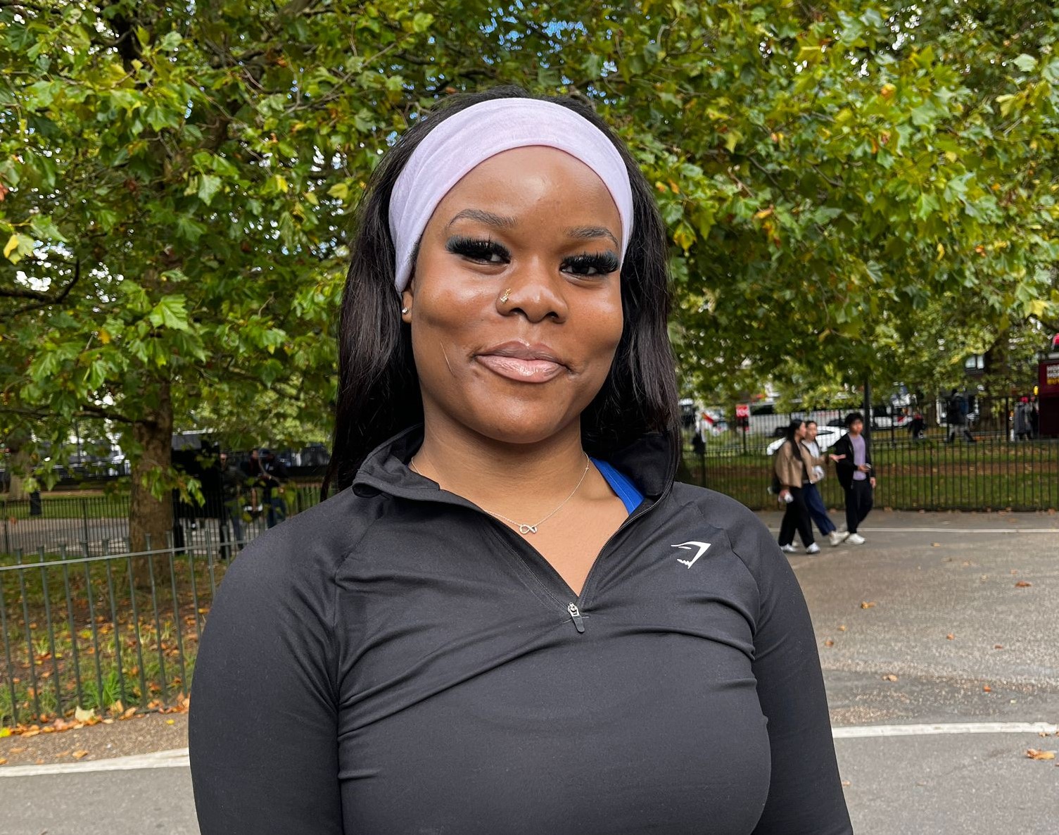 A woman wearing a white headband and black running gear.