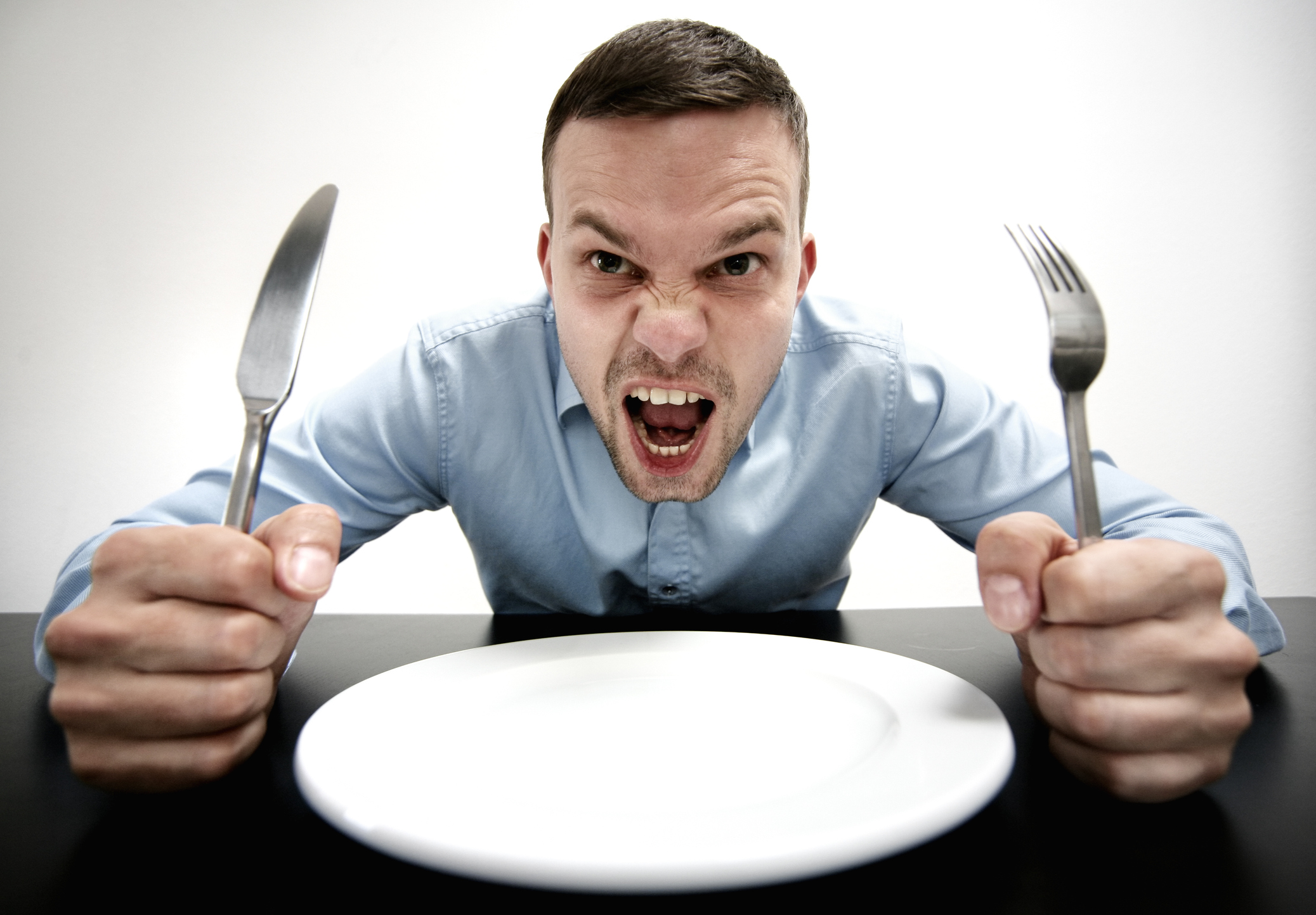 Hoimbre frente a un plato de comida vacío