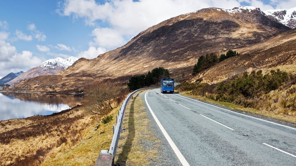 A blue bus on a road at Kyle of Lochalsh