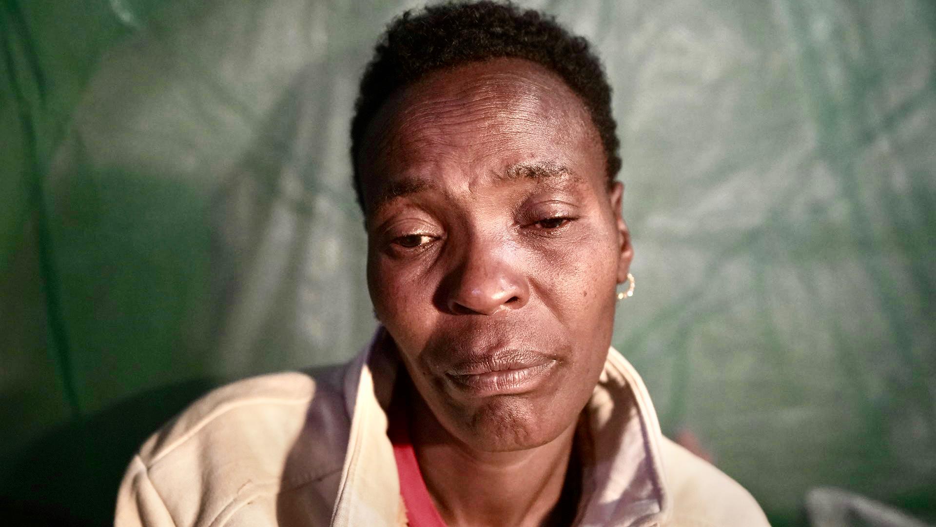 A head and shoulders shot of a woman who looks like she is about to cry.