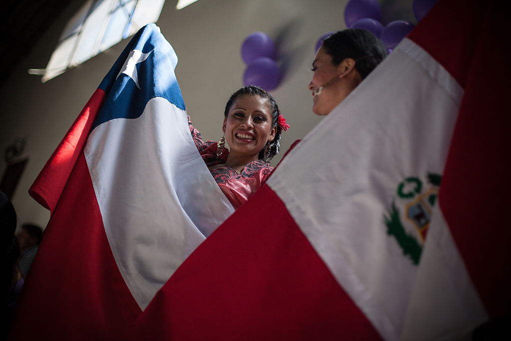 Mujer con banderas de Chile y Perú