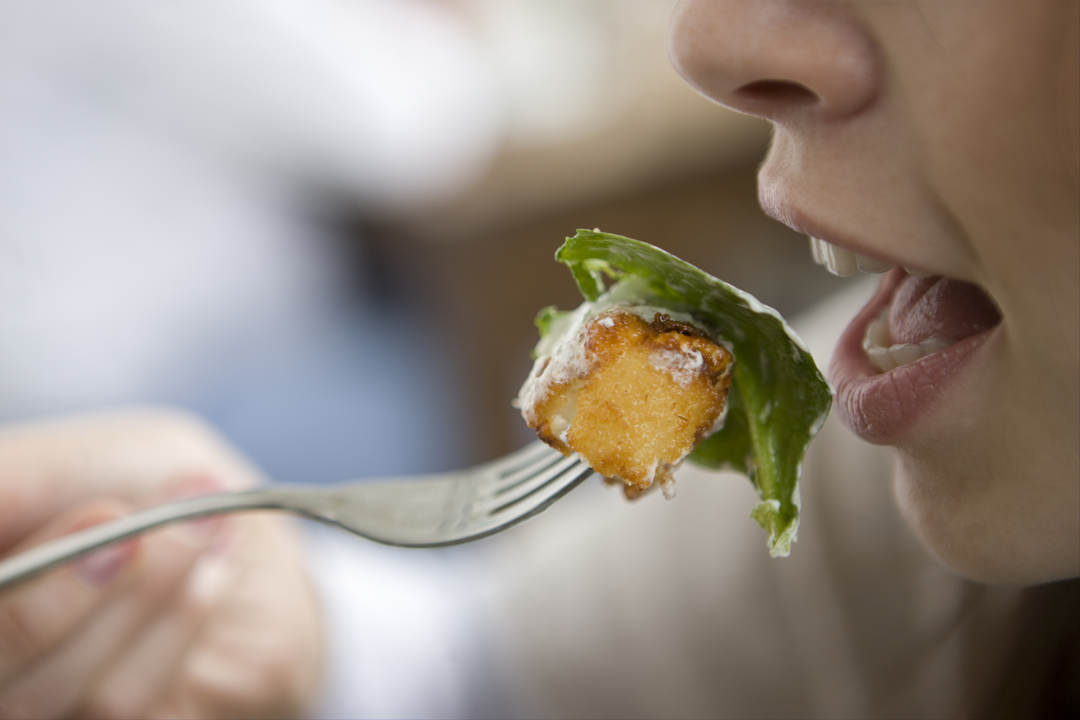 Una mujer se lleva a la boca un tenedor con comida. 