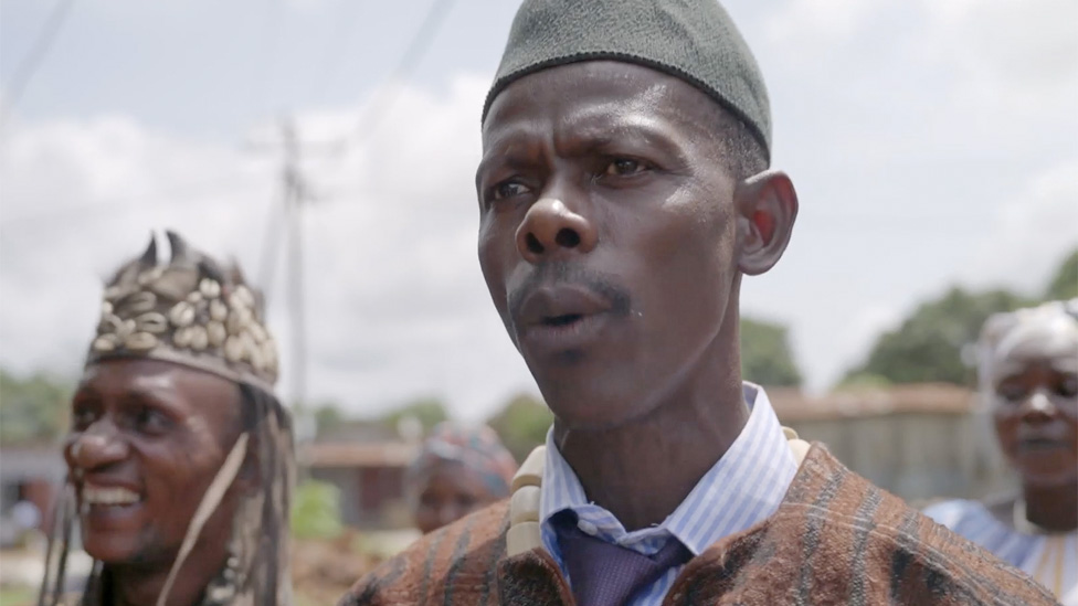Sheku Tarawallie, wearing  a ivory bead necklace and traditional robe