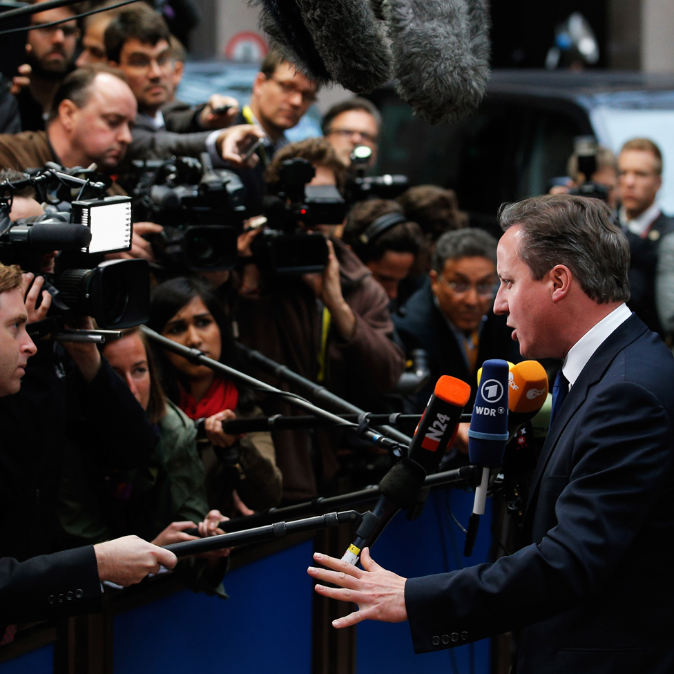 David Cameron speaking to a crowd of cameras and the media