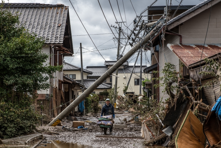  woman helps to clear up a shop that was flooded during Typhoon Hagibis, on October 15, 2019 in Hoyasu near Nagano, Japan