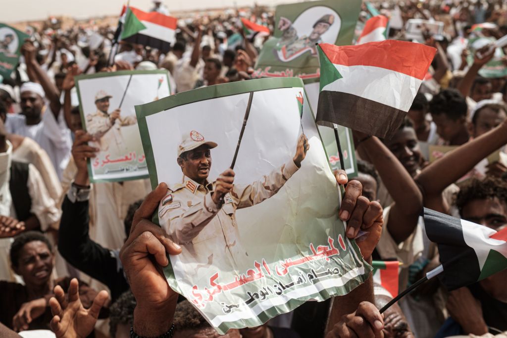 Supporters hold portraits of Hemeti  before a rally in the village of Abraq, about 60km north-west of Khartoum, Sudan