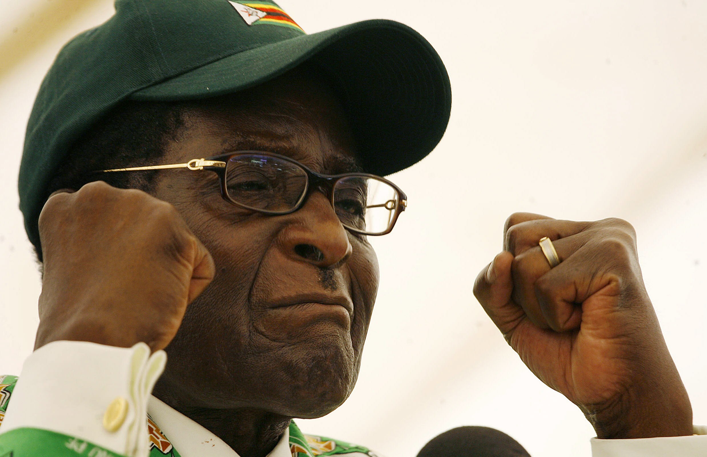 Robert Mugabe, pictured wearing a cap and clenched fists, during 2008 election rally  