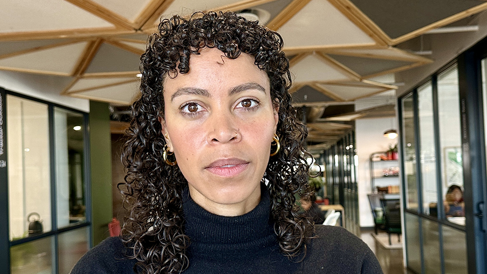 A head shot of Pelonomi Moiloa. She is staring at the camera and wearing a black jumper. 