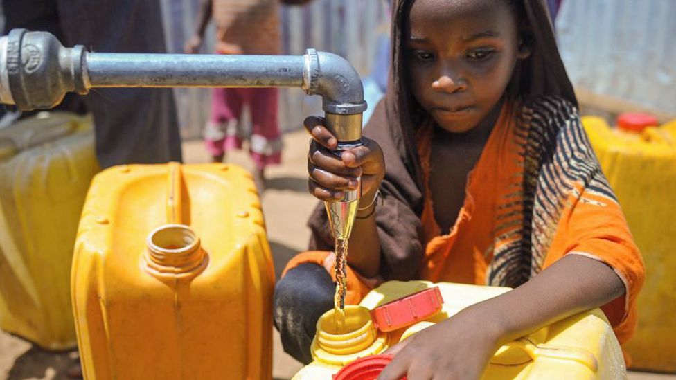 A Somali girl collects water from a well at a camp on the outskirts of Mogadishu, Somalia - March 2018 