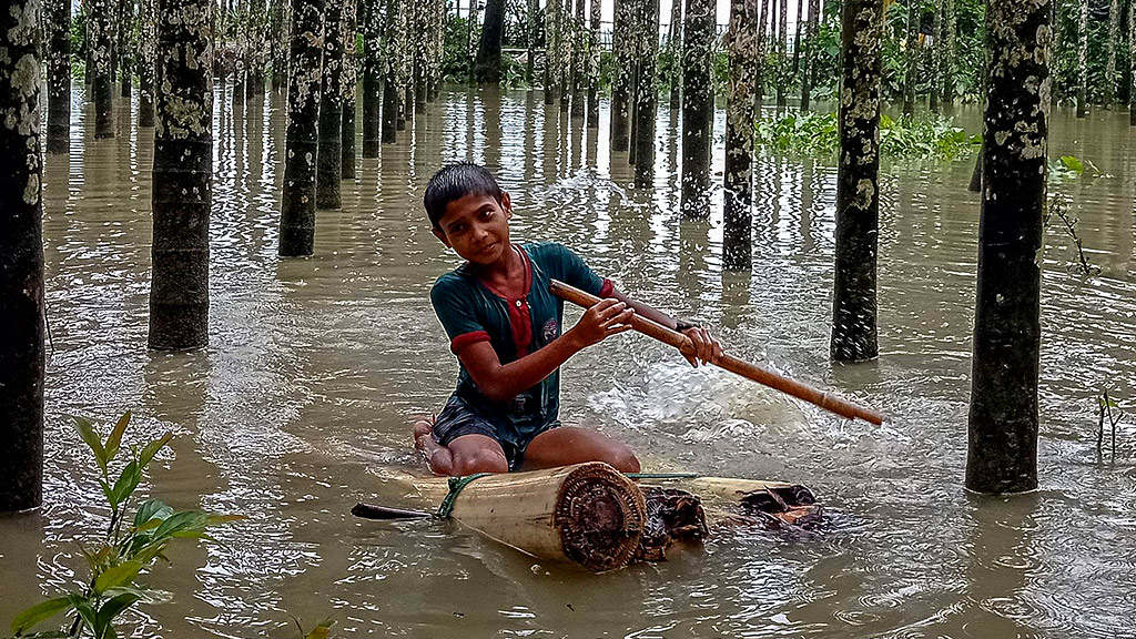 Child uses a makeshift raft to traverse floods. Bangladesh, 2021