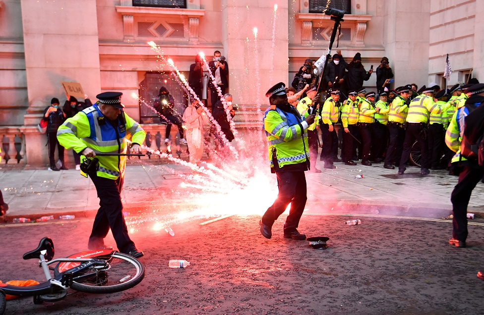 A firework explodes as police officers clash with demonstrators in Whitehall during a Black Lives Matter protes