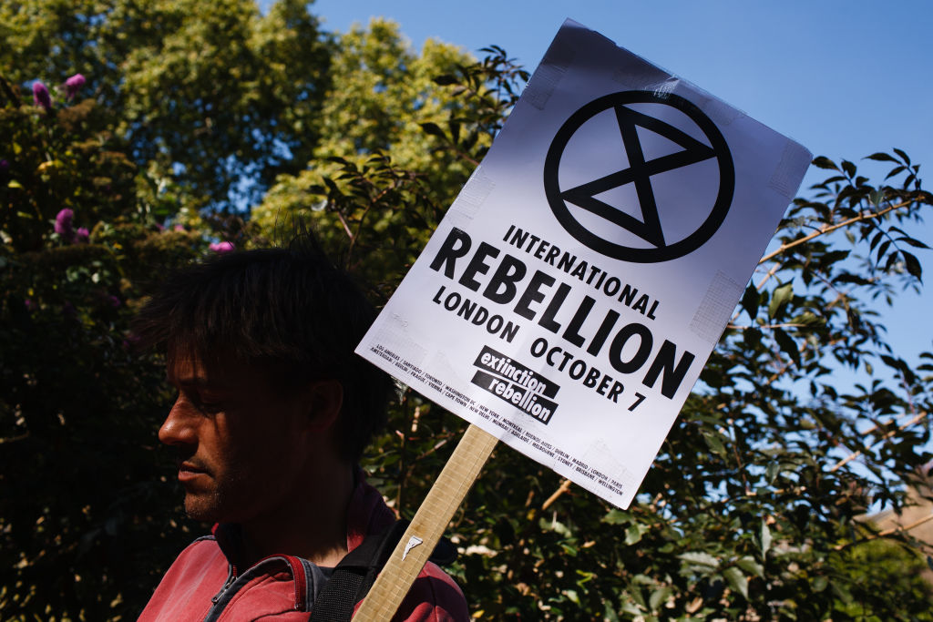 Man holding a Extinction Rebellion placard