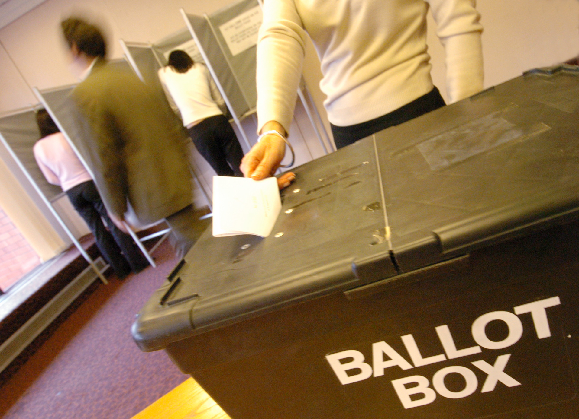 Woman placing vote in ballot box at election