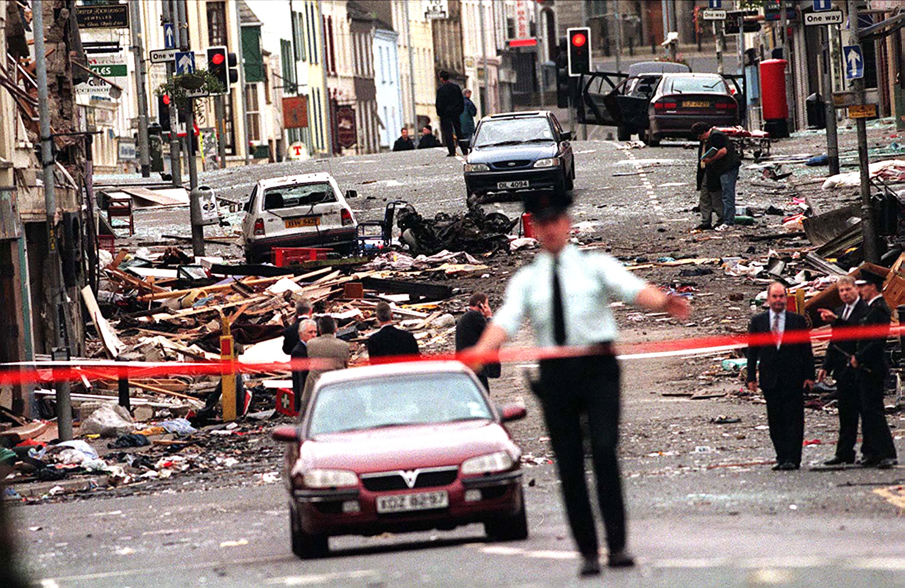 A soldier standing close to a building that has been destroyed by a bomb during the Troubles