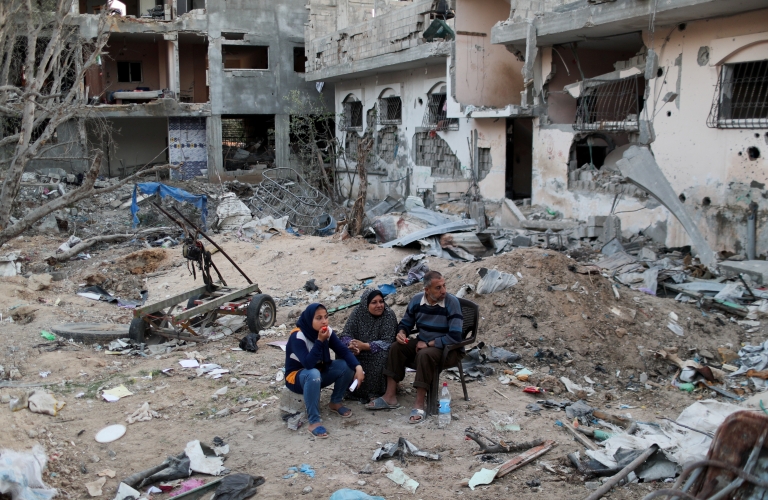 Palestinians sit near destroyed houses in the northern Gaza Strip (1 June 2021)